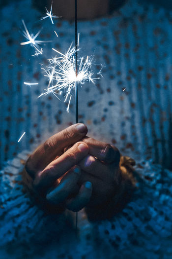 Hand holding sparkler at night