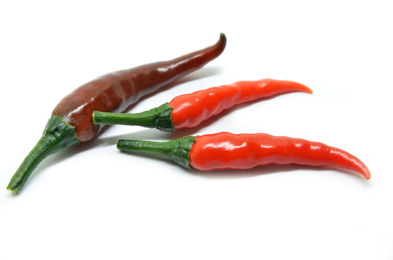 Close-up of chili peppers over white background