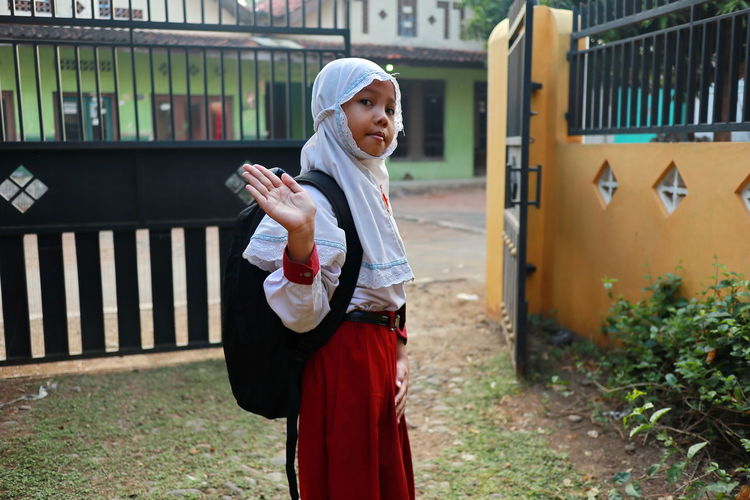 Portrait of girl wearing hijab standing on land