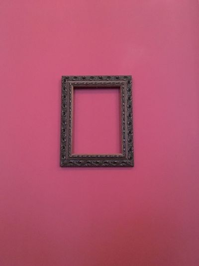 Picture frame hanging on pink wall