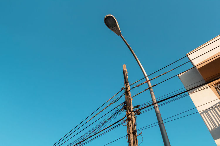 Low angle view of street light against clear blue sky