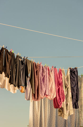 Low angle view of clothes drying on clothesline against sky