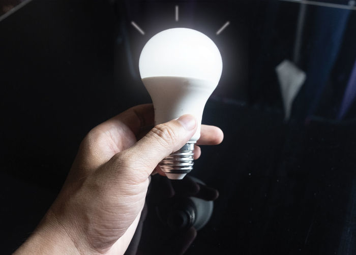 Close-up of hand holding light bulb