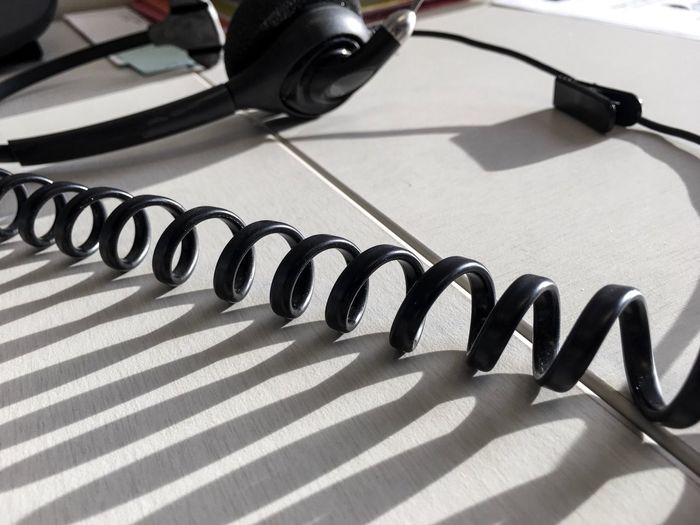 Close-up of cord by headphones on table