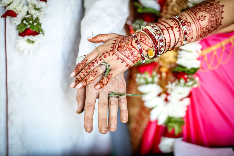 Midsection of bridegroom stacking hands during wedding ceremony