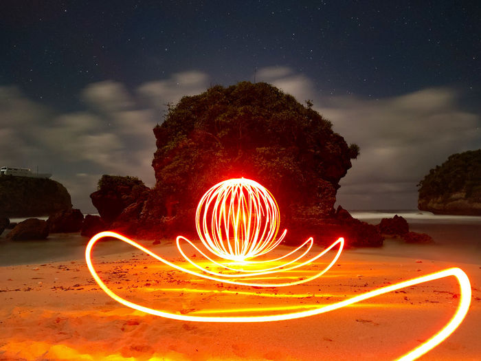 Light painting on beach against sky at night