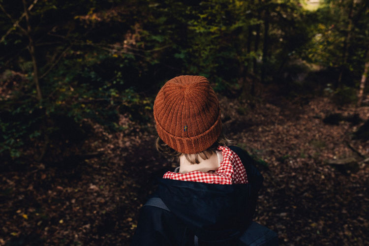 High angle view of woman wearing knit hat standing in forest