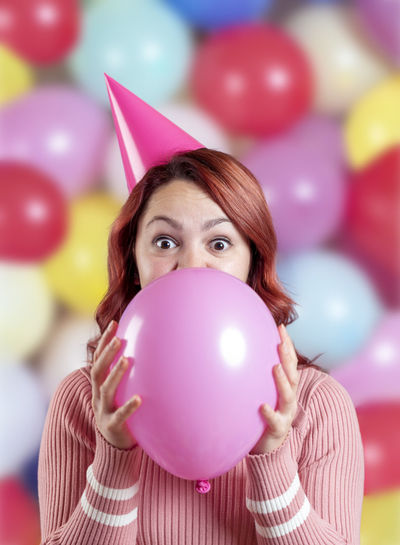 Portrait of woman holding pink balloons
