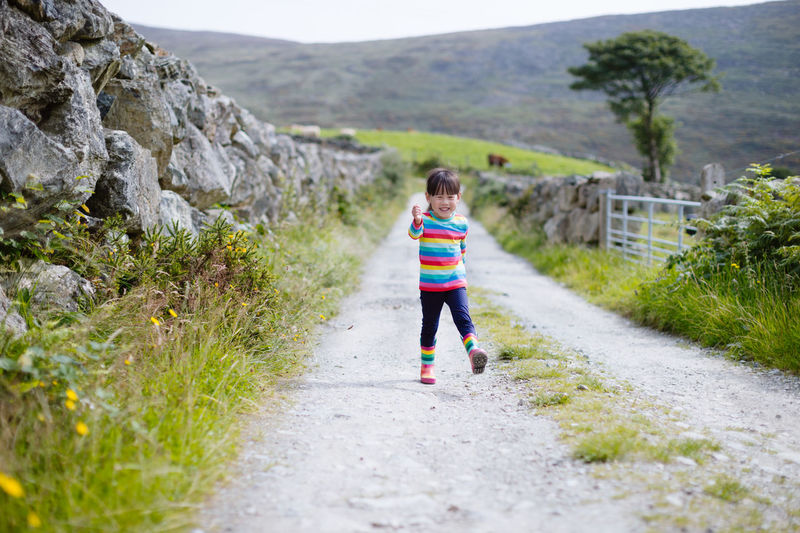 Young girl walking on summer countryside road