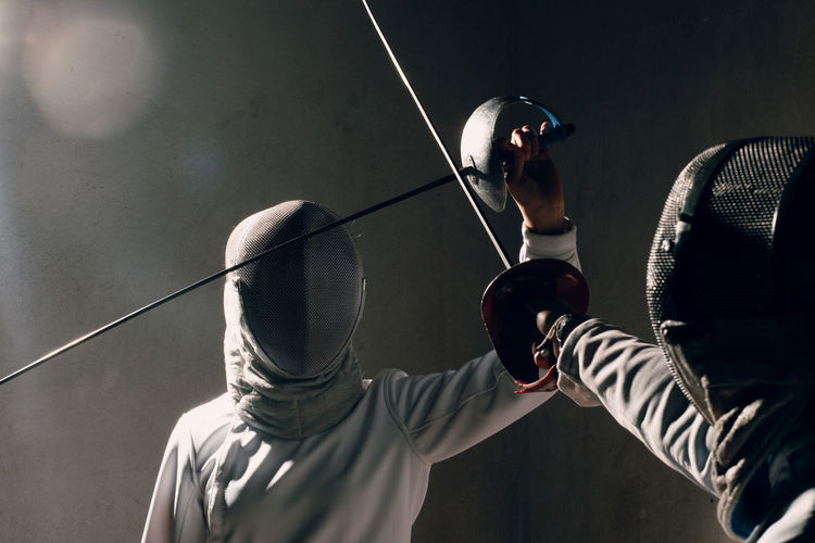 Close-up of men using sword