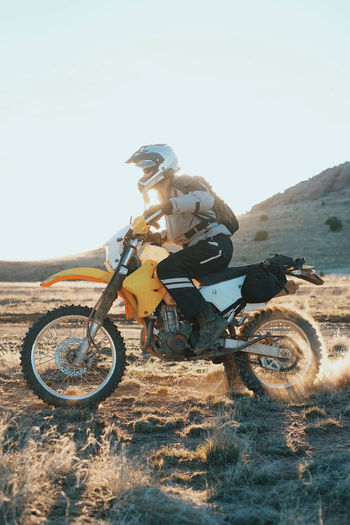 Man on motorcycle in desert during sunset