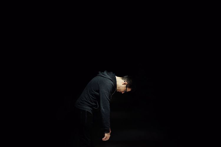 Side view of man against black background