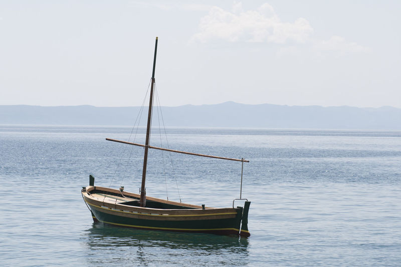 Boat moored on sea against sky