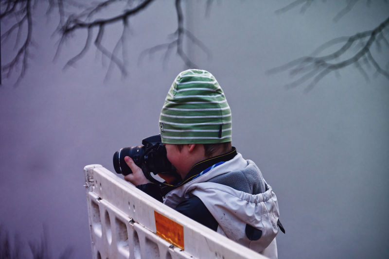 Portrait of child takin pictures with dslr camera