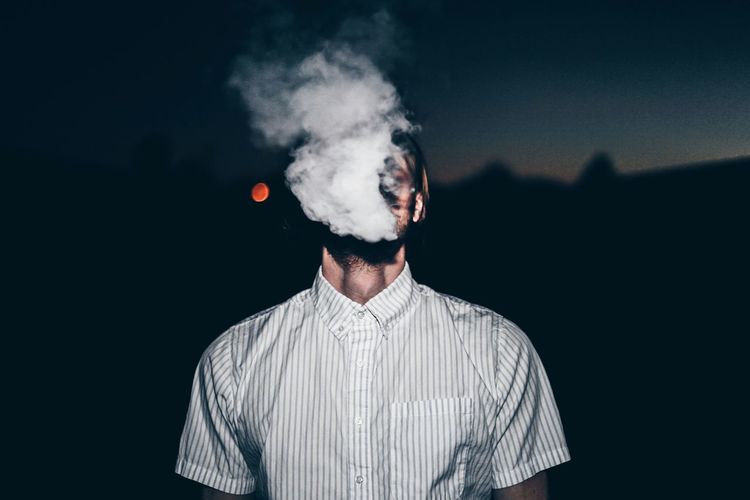 Man smoking against blurred background