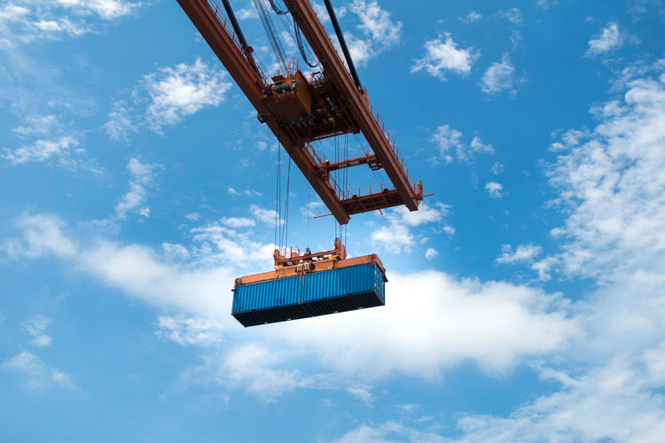 Low angle view container pick up by quantry crane against sky.