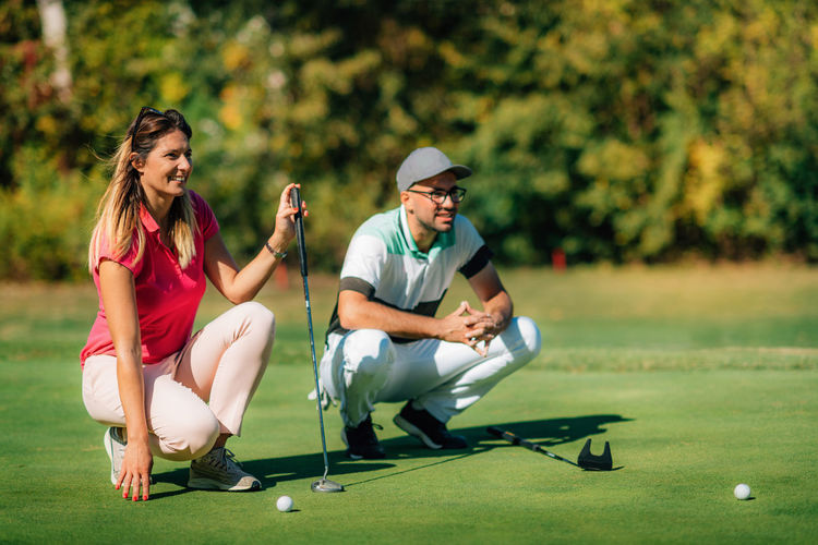 Golfing lifestyle. golf couple on the putting green, enjoing the beautiful sunny day