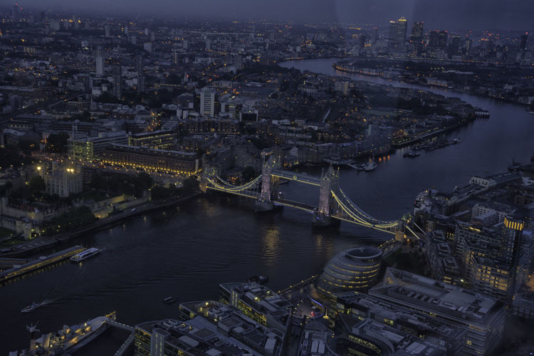 High angle view of illuminated tower bridge over thames river at dusk