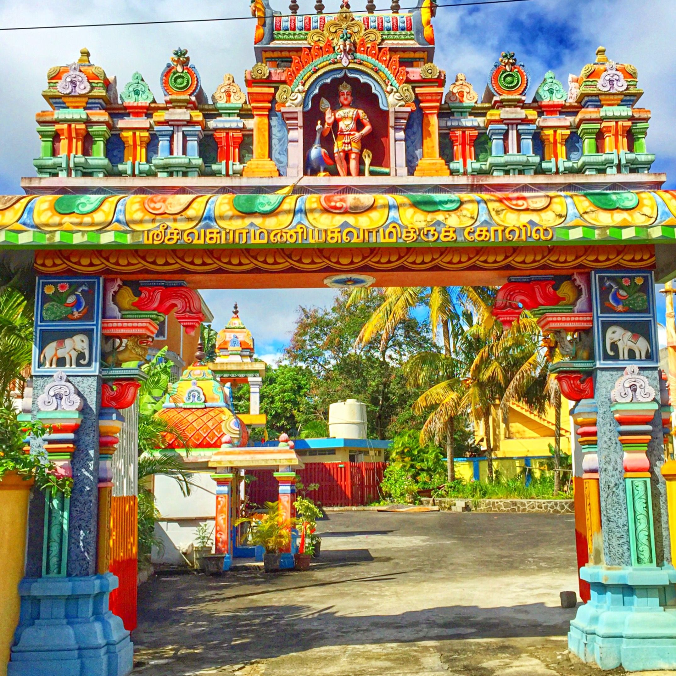 art and craft, art, architecture, creativity, built structure, building exterior, human representation, place of worship, sculpture, statue, religion, spirituality, multi colored, temple - building, sky, animal representation, yellow, low angle view