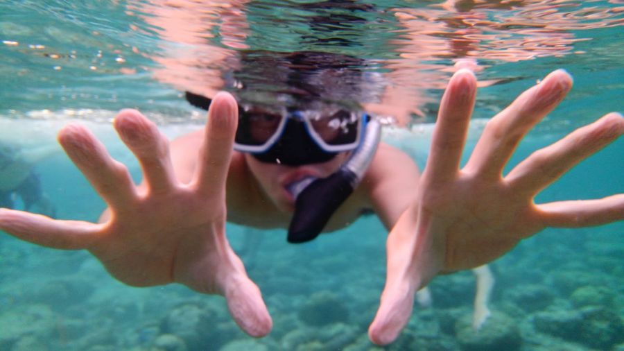 Reflection of man swimming in sea
