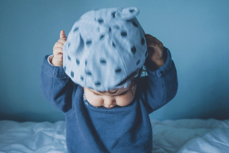 Cute girl with cap sitting on bed