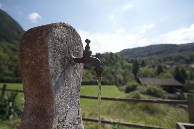 Close-up of old faucet against the sky