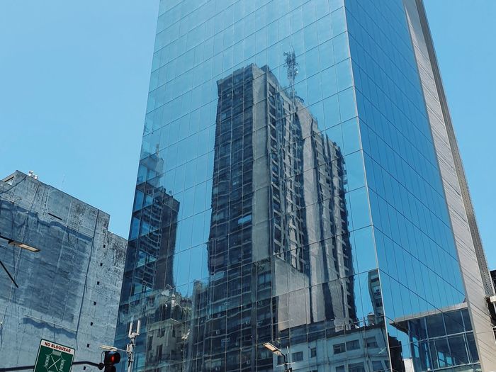 Low angle view of modern buildings against blue sky