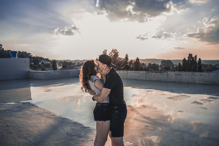 Couple kissing at poolside during sunset