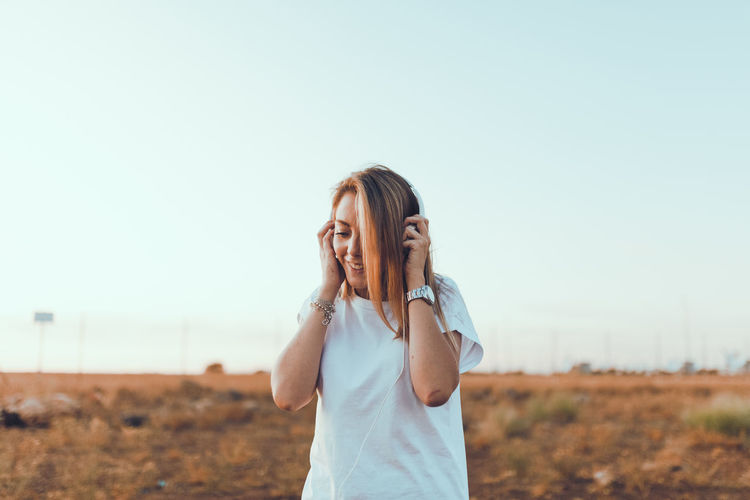 Young woman standing on land against clear sky