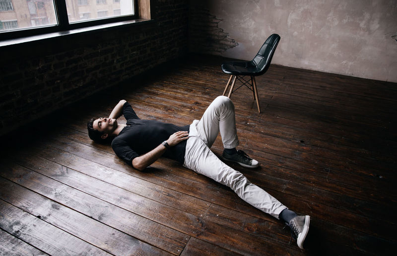 Handsome man lying on hardwood floor at film studio