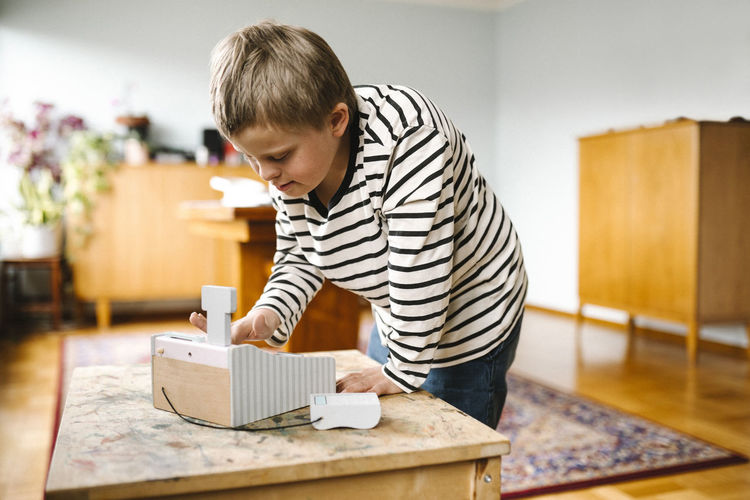 Side view of boy playing with toy blocks at home