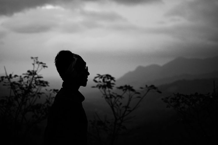 Side view of silhouette man standing against sky