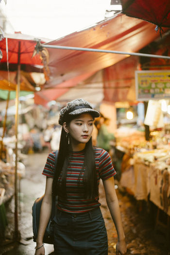 Beautiful young woman standing at market