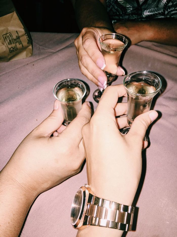 Cropped hands of friends toasting drinks