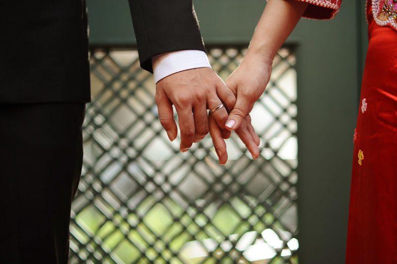 Midsection of couple with holding hands