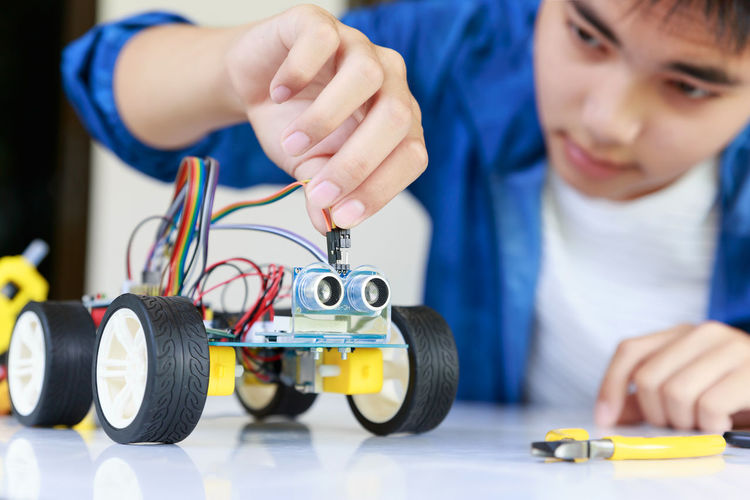 Teenager boy working on robotic toy