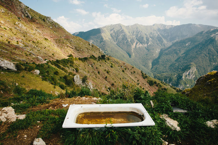 Old bath tub for relaxing with landscape view of mountain peaks. green calm enviroment for leasure.