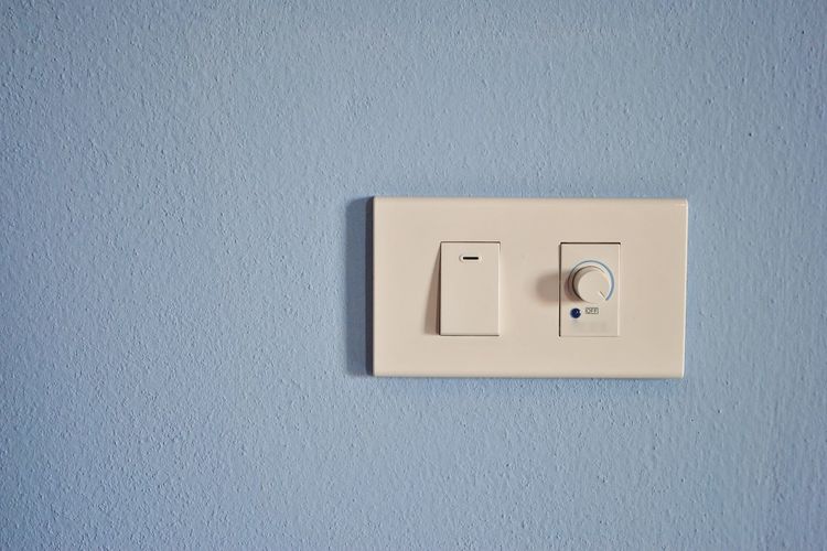 Light switch mounted on blue wall