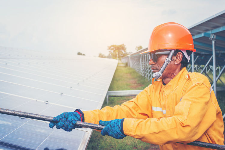 Manual worker working by solar panels
