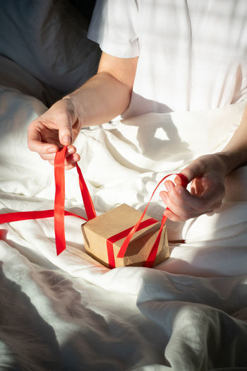 Girl unpacks a small gift in bed