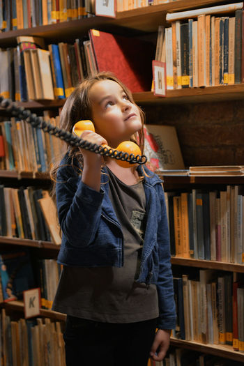 Girl holding telephone receiver at library