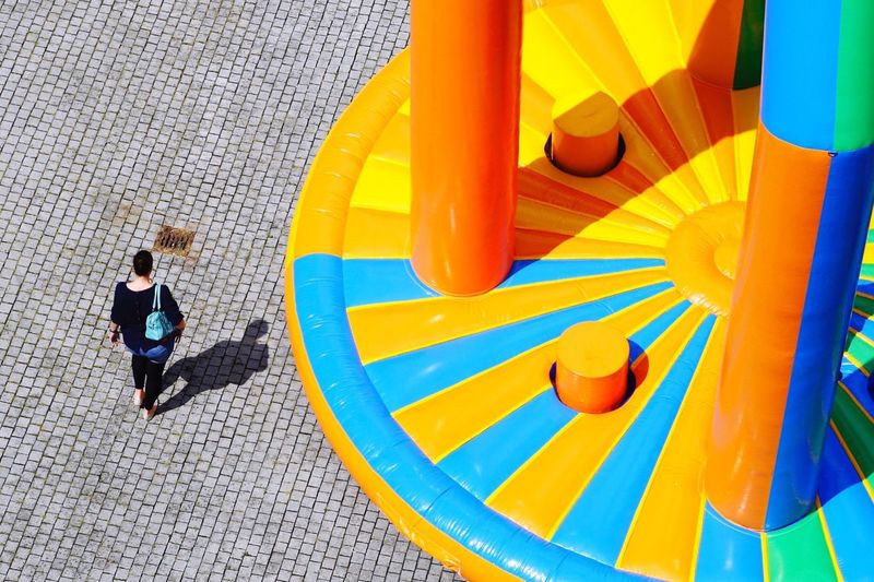 High angle view of woman walking on street with bouncy castle