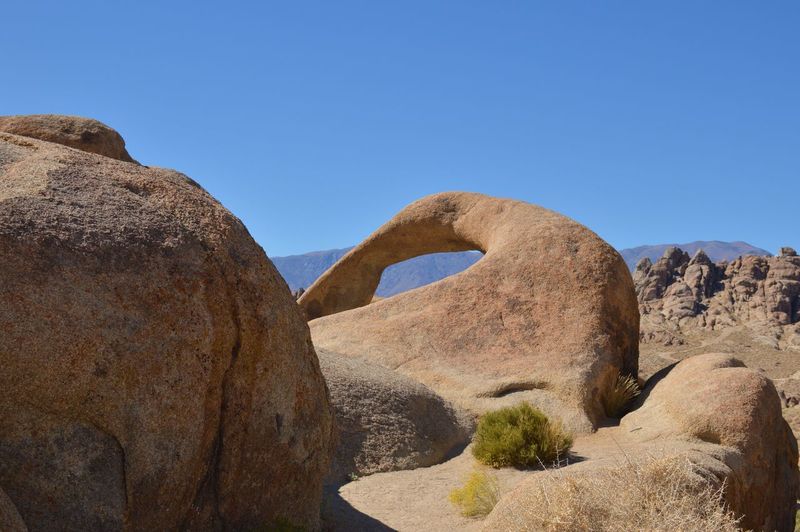 Rock formations on landscape against clear blue sky