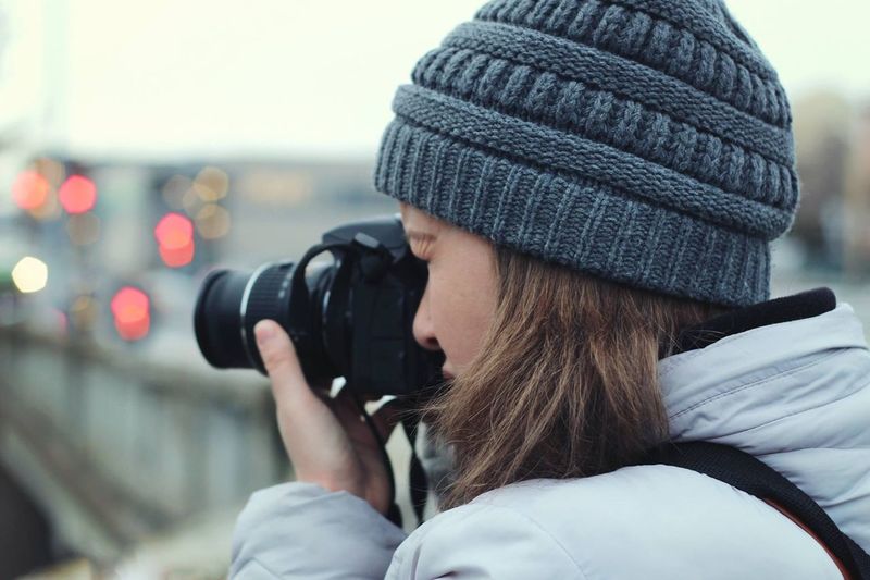 Close-up of woman wearing knit hat photographing through camera
