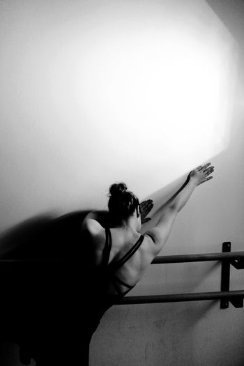Young woman standing against white wall