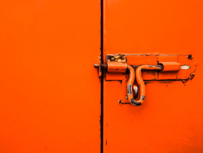 Close-up of latch on orange door