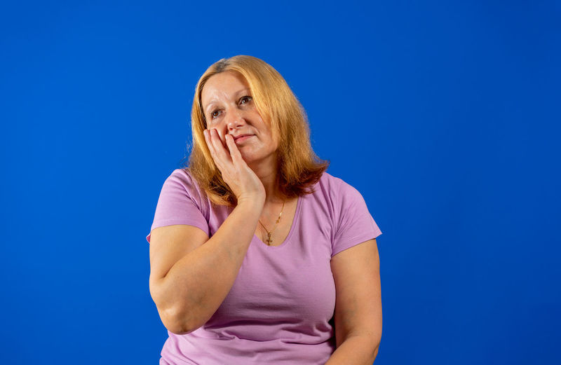 Portrait of a smiling woman against blue background