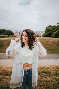 Beautiful woman looking away standing against sky