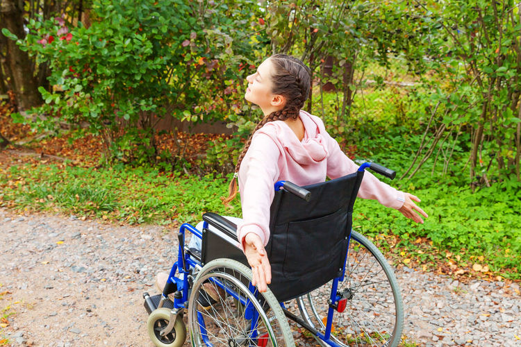 Side view of woman sitting on wheelchair