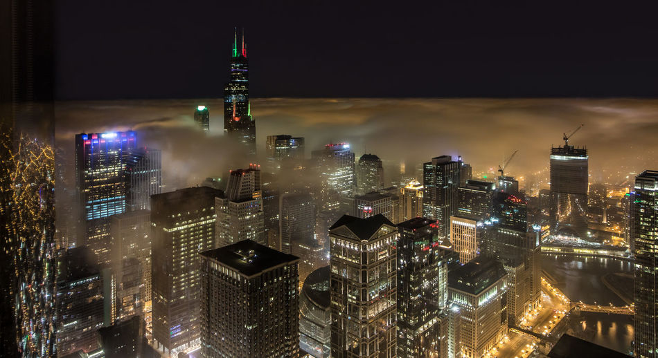 Illuminated cityscape in foggy weather
